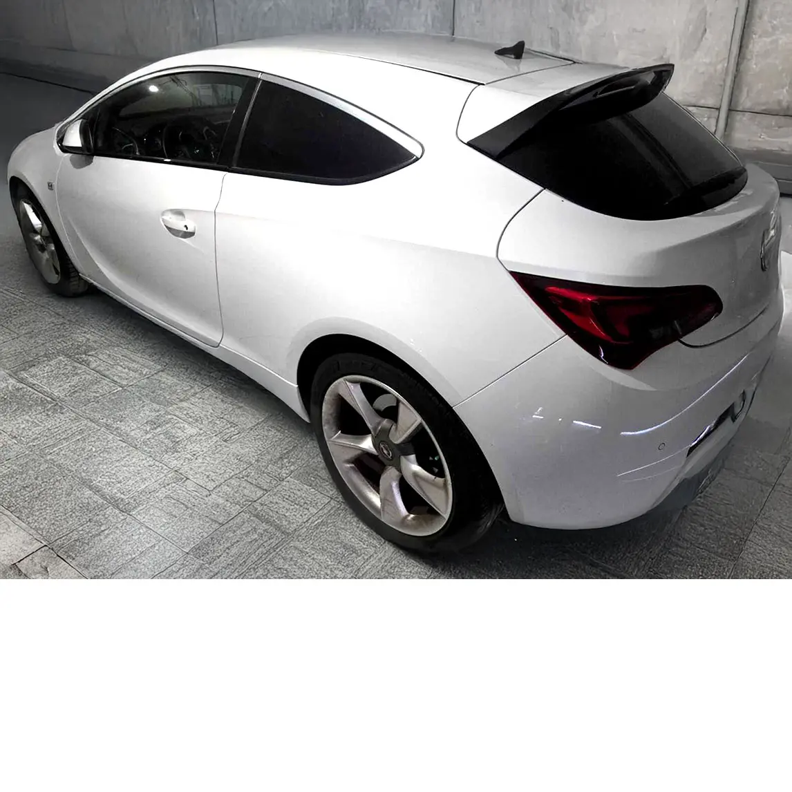 Opel Astra J GTC 1.6 Turbo branco visto de traseira lateral esquerda, estacionado em ambiente interior