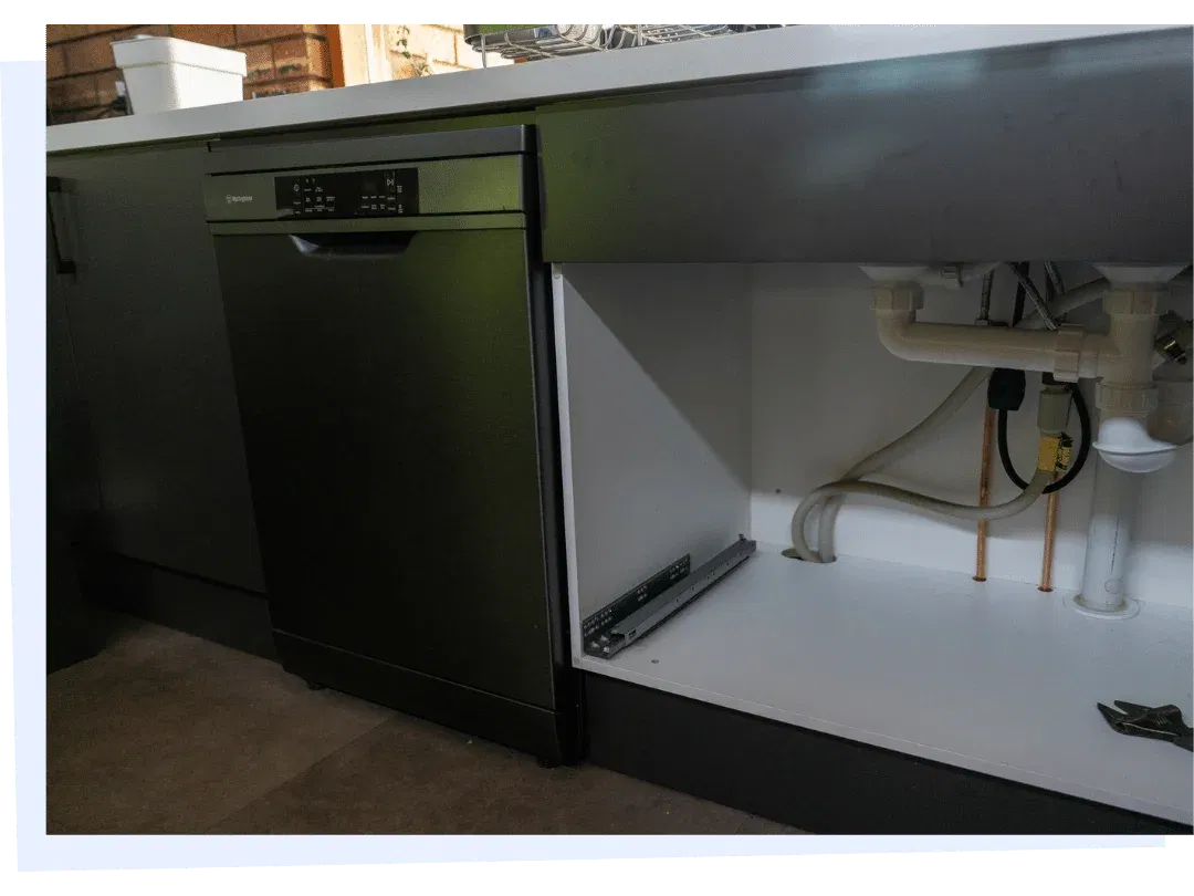 Dishwasher installation with plumbing connections under kitchen sink