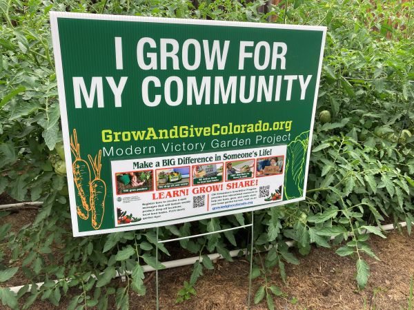 a green yard sign reading "I grow for my Community"